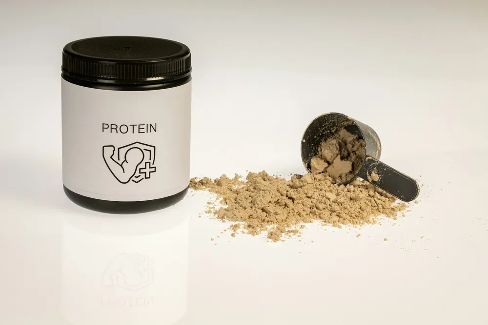 Tub of protein powder with a scoop